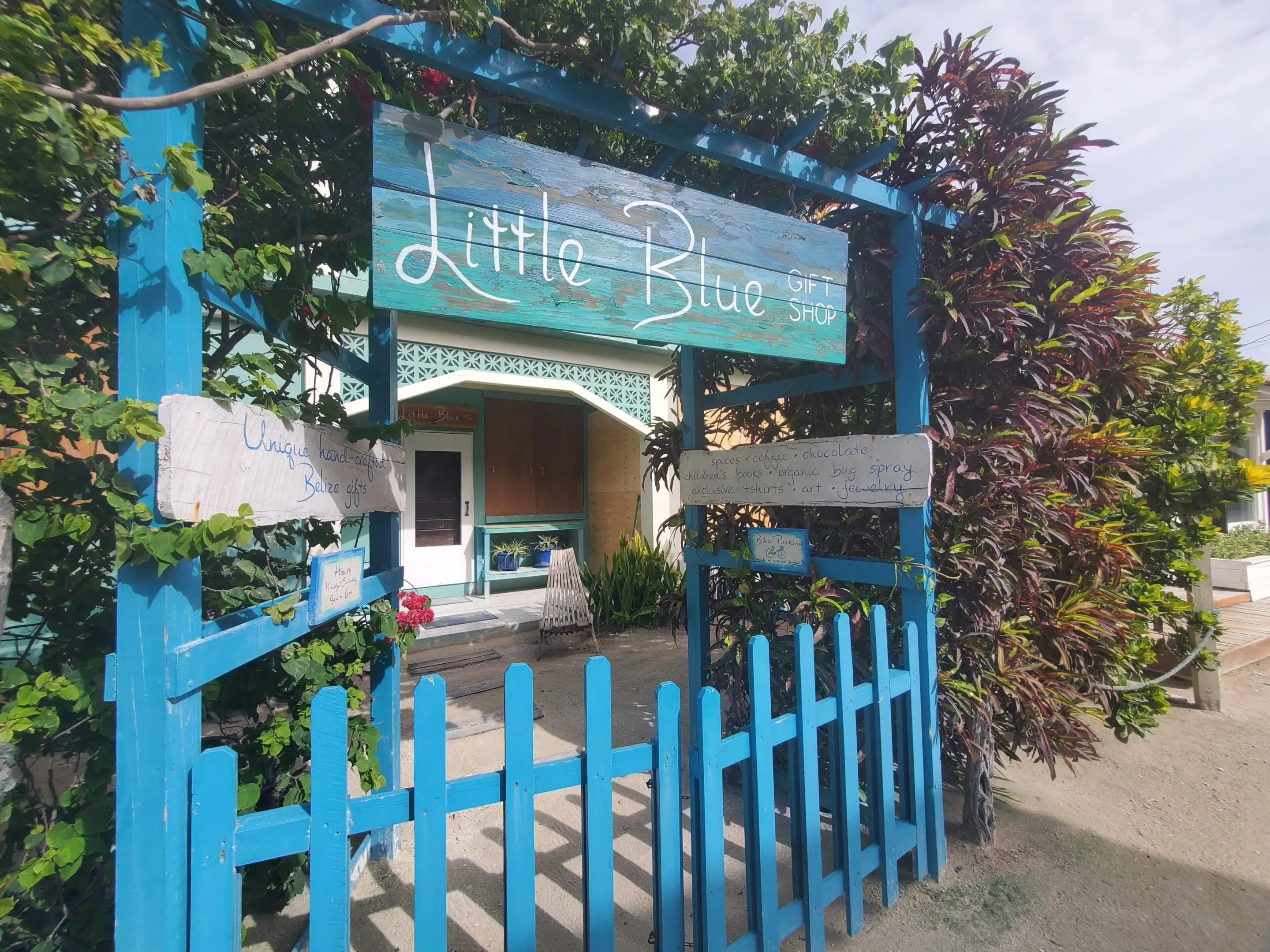 A blue fence and sign for little bleu