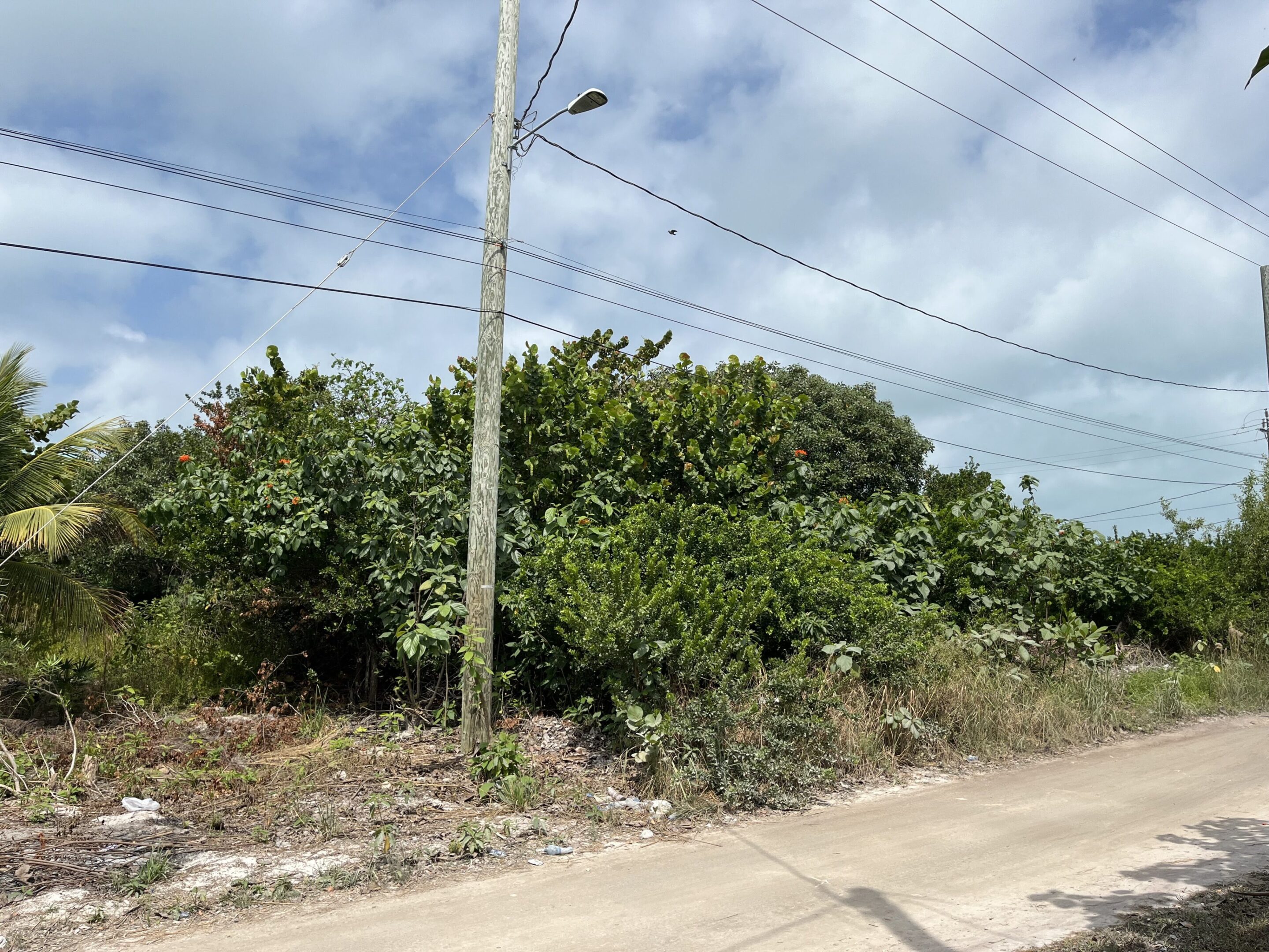 A power pole and street light on the side of a road.