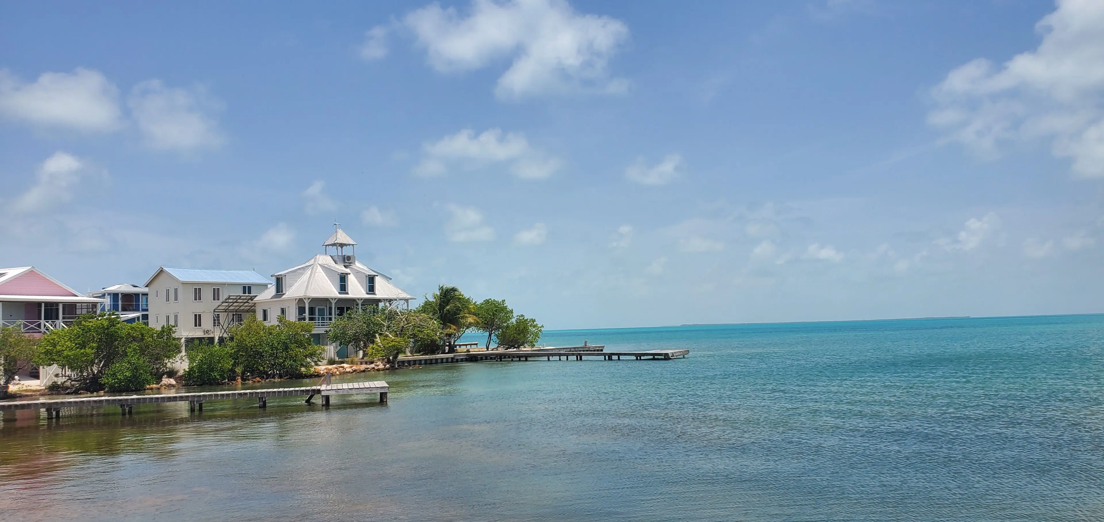 A house on the water with a dock in front of it.