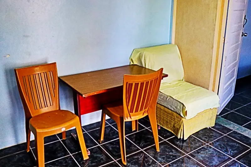 A table and chairs in a room with tile floors.