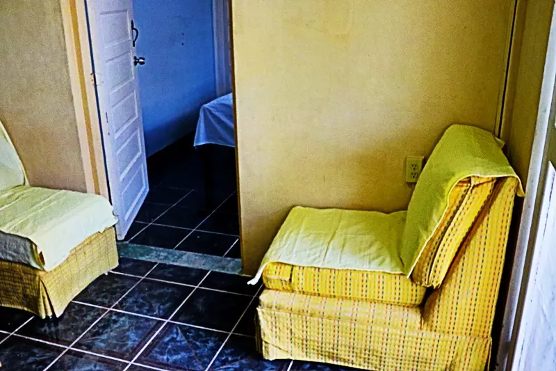 A yellow chair in the corner of a room.