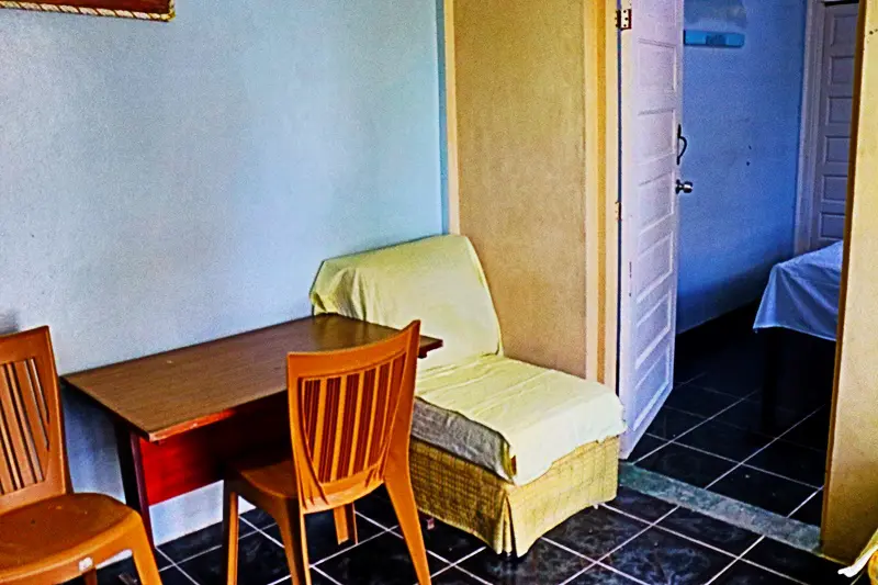 A table and chair in the corner of a room.