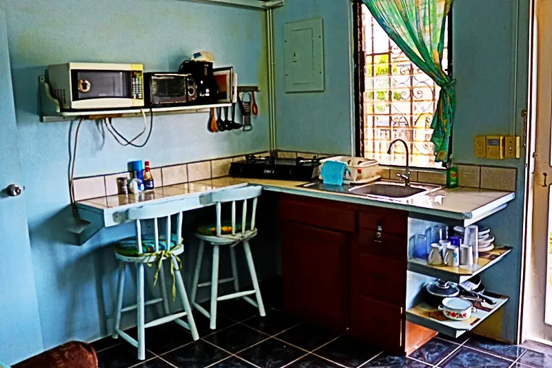 A kitchen with two chairs and a microwave.