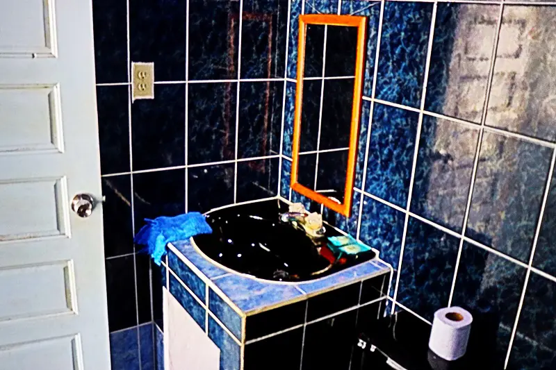 A bathroom with blue tile and black sink.