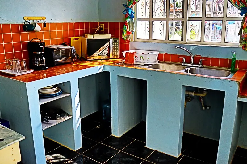 A kitchen with blue cabinets and red tile