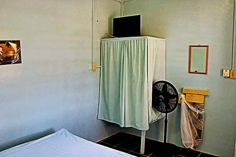 A room with a bed and a fan