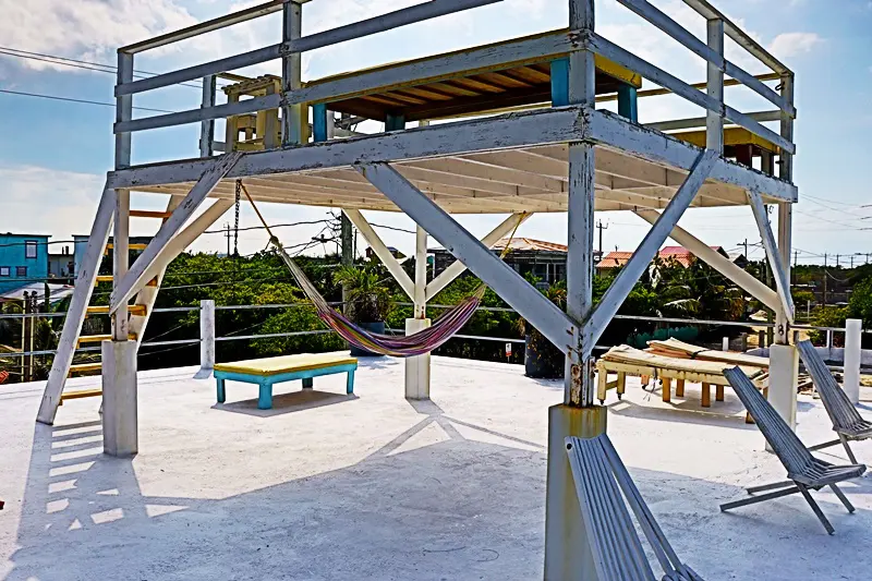 A hammock hanging from the side of an elevated platform.