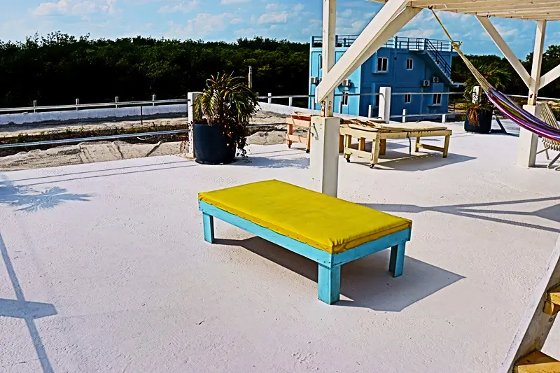 A yellow bench on the ground near some trees