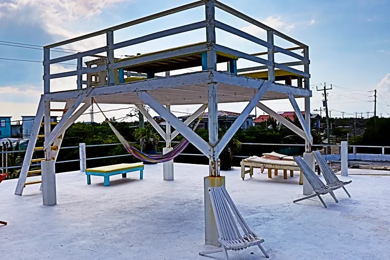 A beach with a deck and hammock chairs