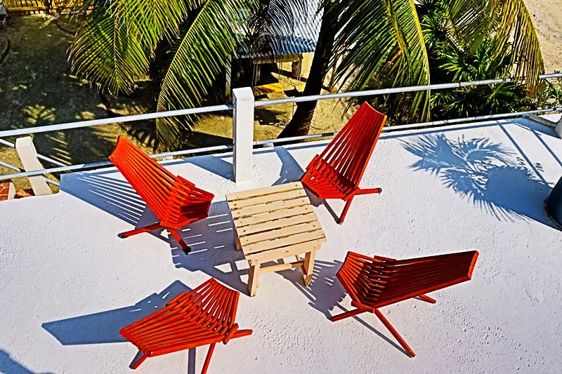 A group of red chairs sitting on top of a white deck.