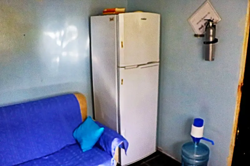 A white refrigerator freezer sitting in the corner of a room.