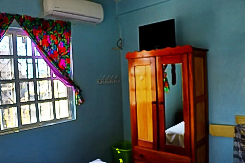 A bedroom with blue walls and wooden furniture.