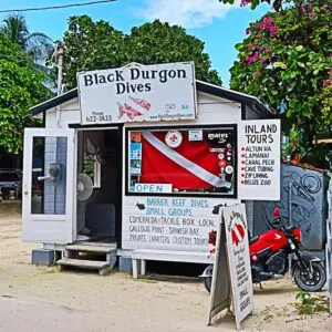 A white building with signs and a motorcycle parked in front of it.