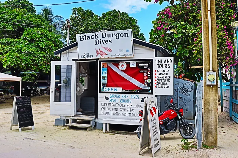 A white building with signs and a motorcycle parked in front of it.