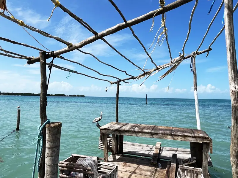 A wooden structure on the water with blue sky in background.