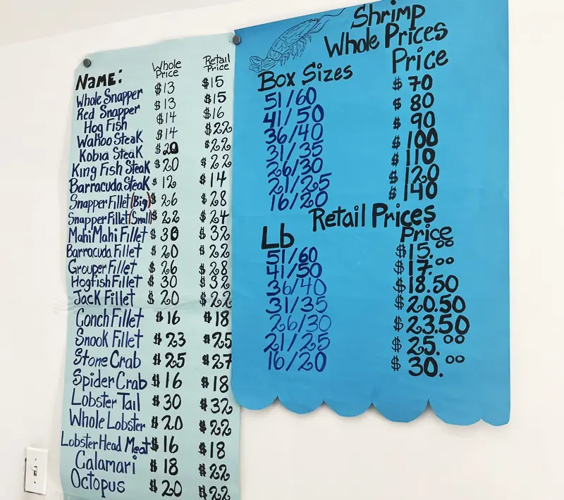 A blue sign with prices for different items.