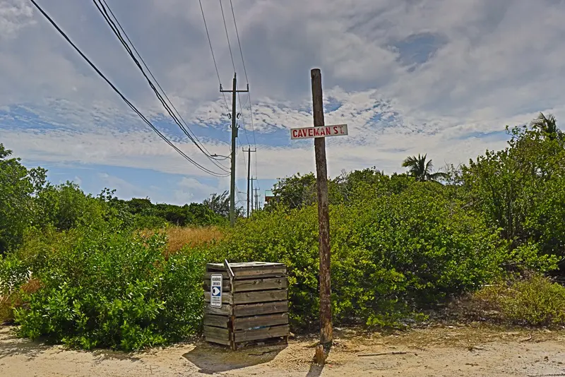 A wooden box sitting next to a pole.