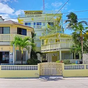 A yellow house with palm trees in front of it.