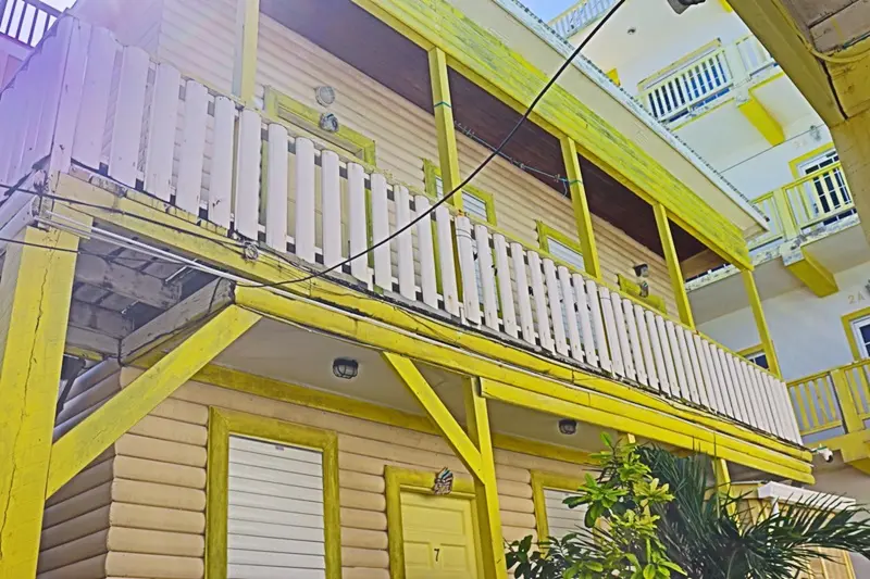 A yellow and white building with a balcony.