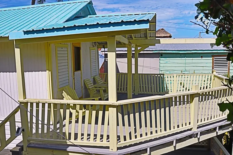 A porch with a blue roof and yellow railing.