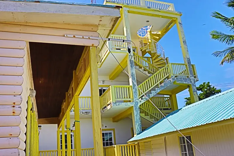 A yellow building with stairs going up it.