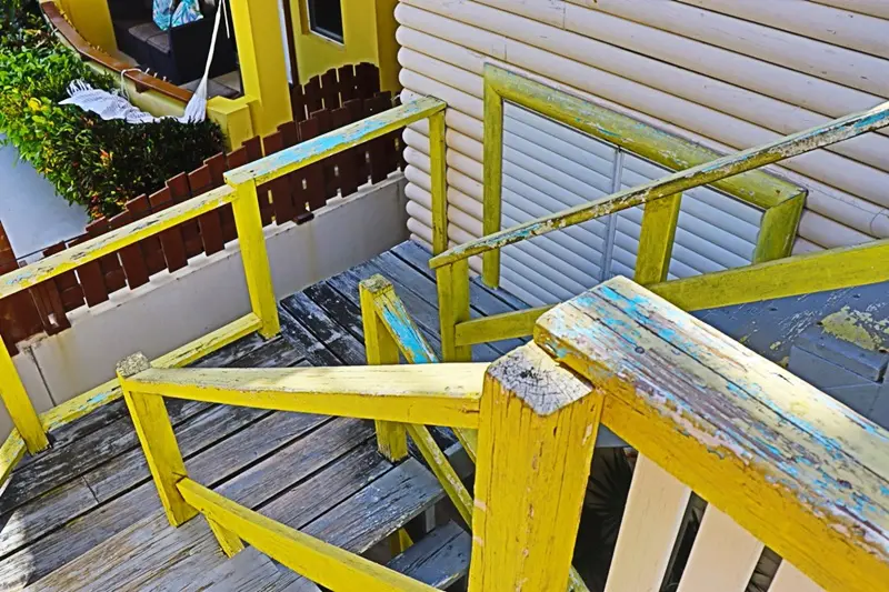 A yellow wooden staircase with steps and railing.