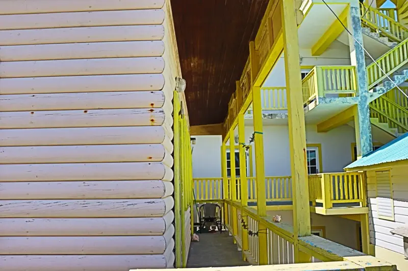 A yellow and white building with stairs going up the side.