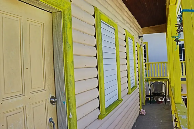 A house with green trim and yellow windows.