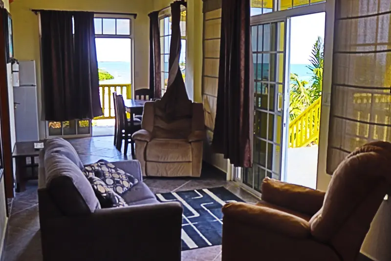 A living room with couches and chairs, and sliding glass doors.