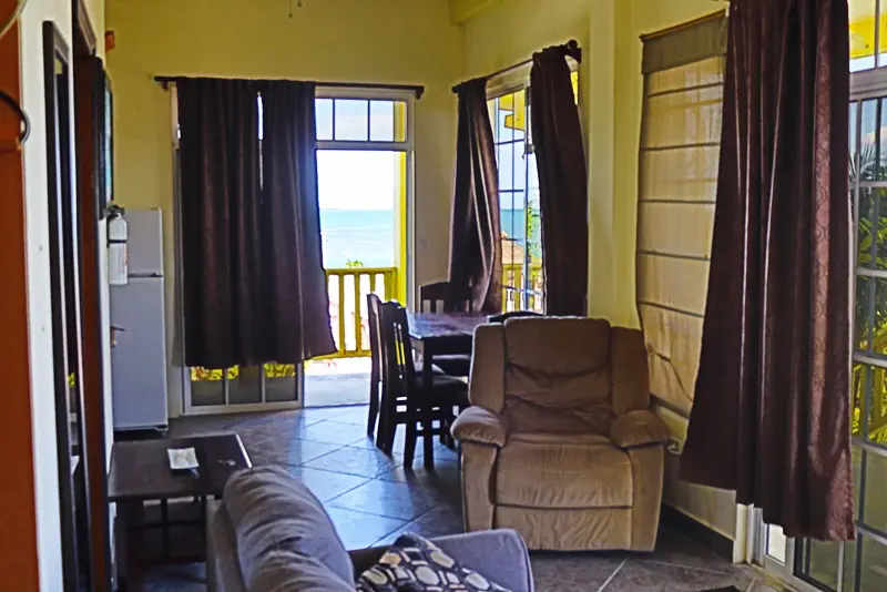 A living room with brown walls and yellow curtains.