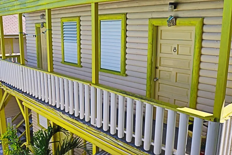 A house with yellow trim and white railing.