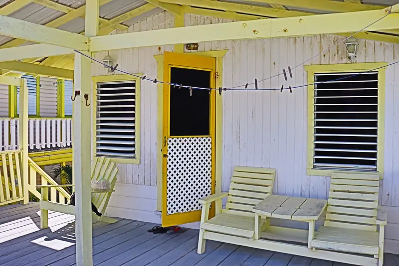 A porch with two chairs and a table.