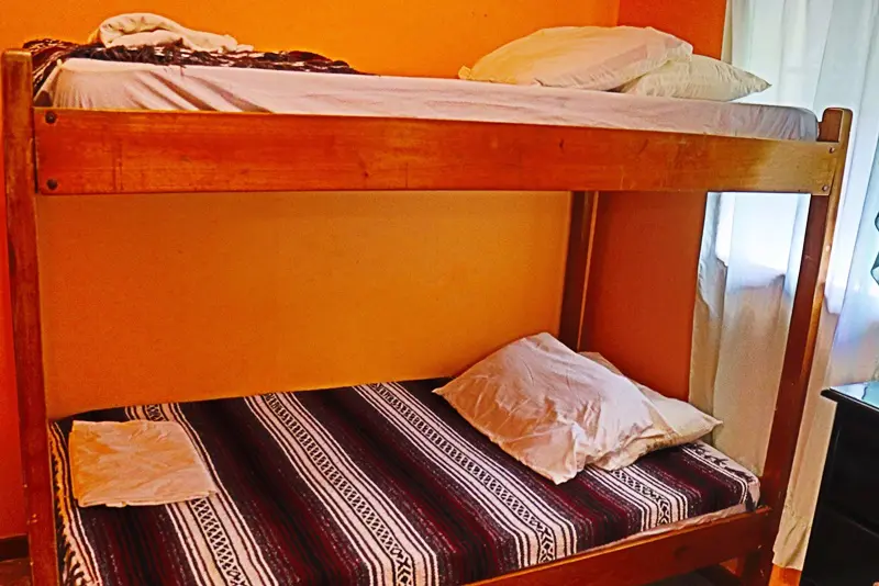 A bunk bed with two pillows and blankets on top of it.