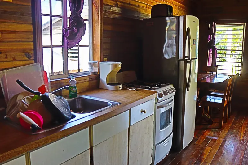 A kitchen with white cabinets and wooden floors.