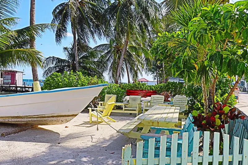 A beach with chairs and a boat in the background.