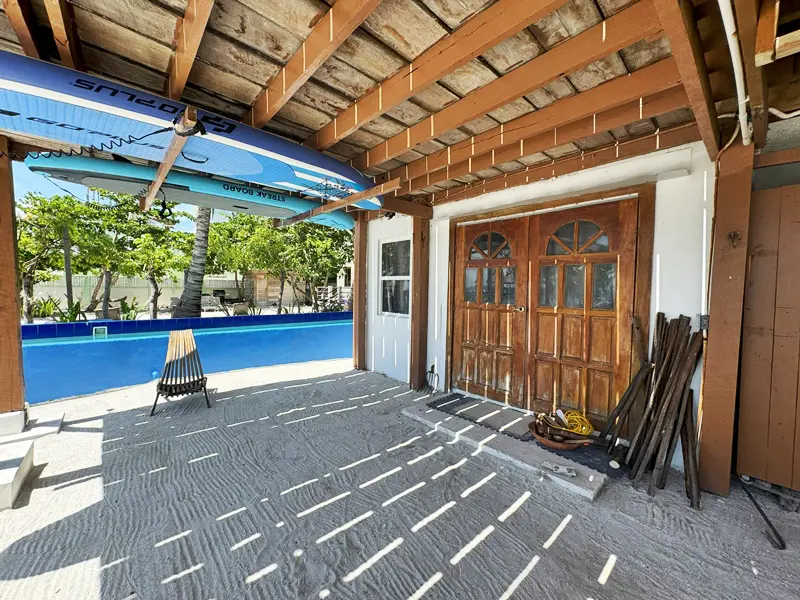 A wooden garage door in front of a pool.