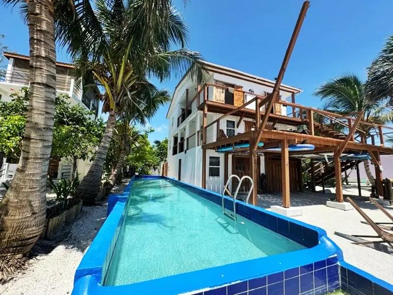 A pool with a blue tile bottom and a wooden deck.