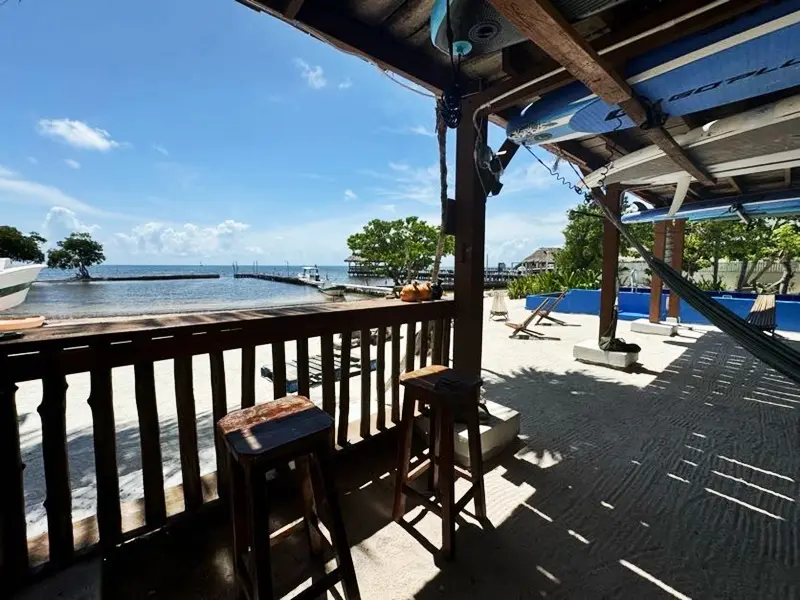 A deck with chairs and tables on the beach.