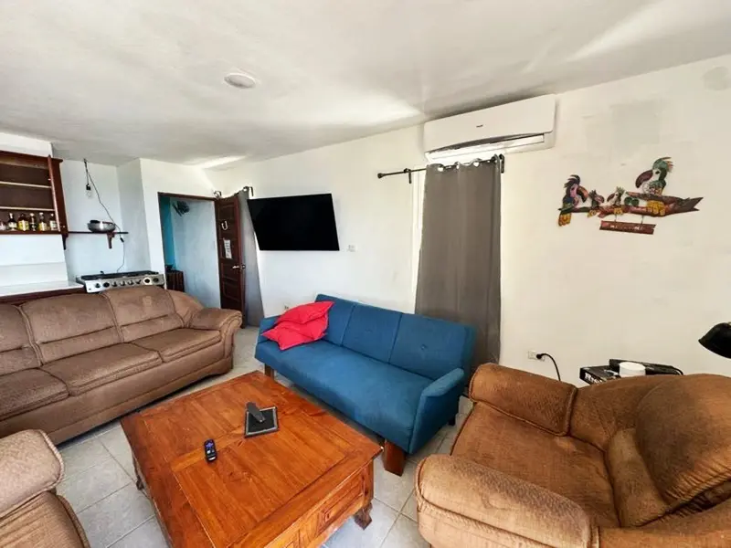 A living room with couches, coffee table and television.