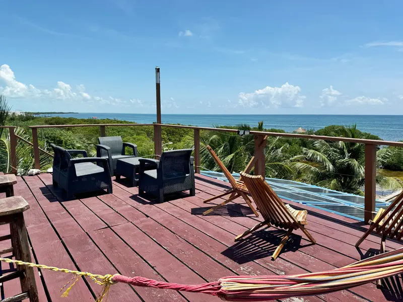 A deck with chairs and a view of the ocean.