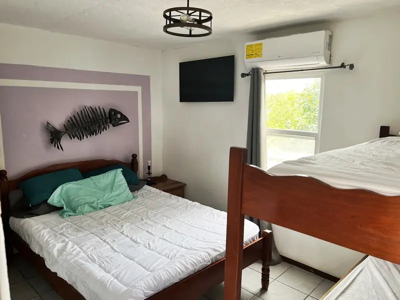 A bedroom with two beds and a tv on the wall.