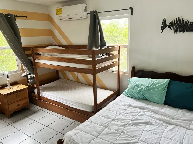 A bedroom with two beds and a window.