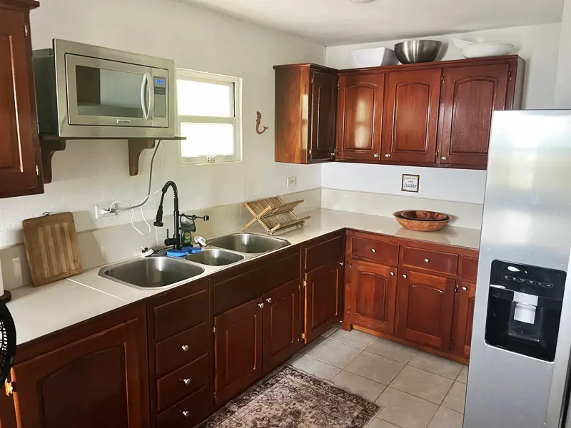 A kitchen with wooden cabinets and white walls.