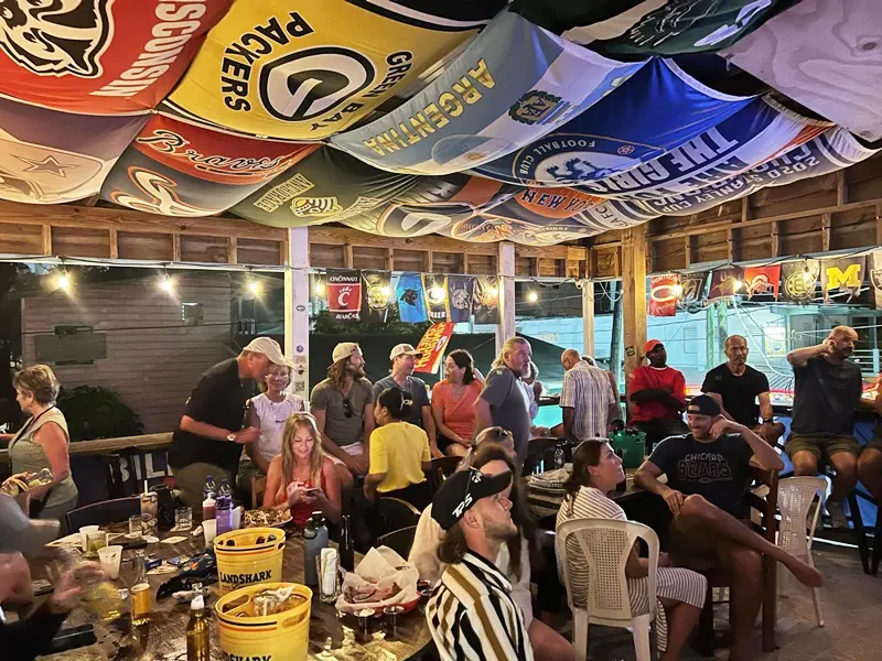 A group of people sitting at tables under umbrellas.