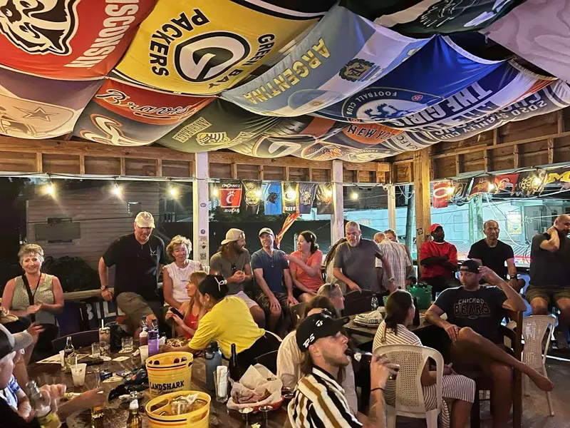 A group of people gathered around tables with food.