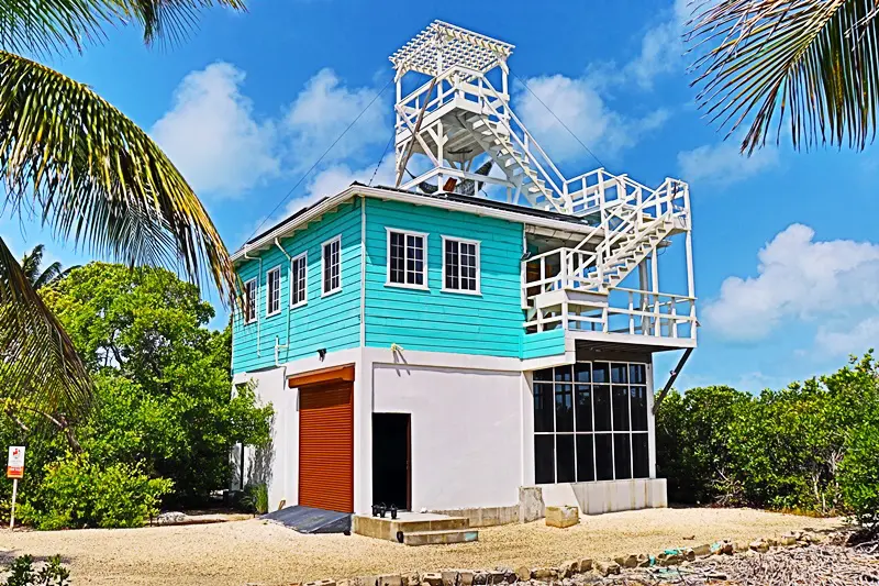 A blue and white building with stairs going up it.