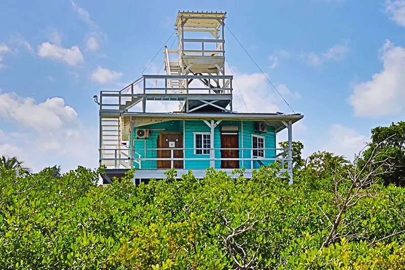 A blue house with a tower on top of it.