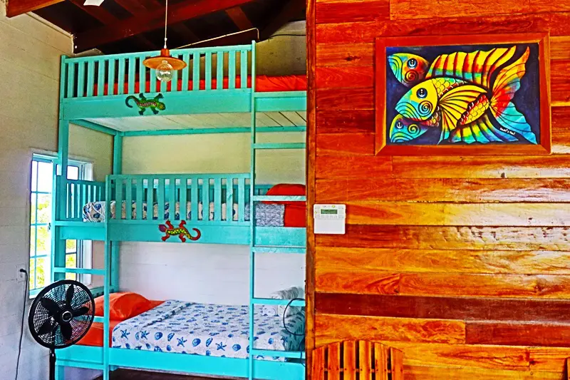 A room with bunk beds and wooden walls.