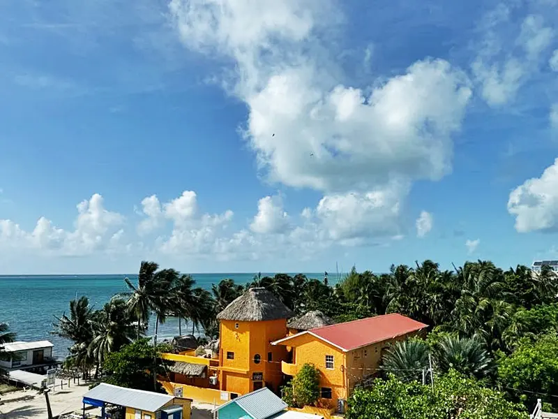 A yellow building with a red roof and some trees