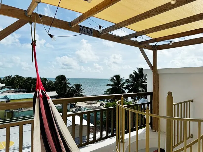 A hammock hanging from the side of a balcony.